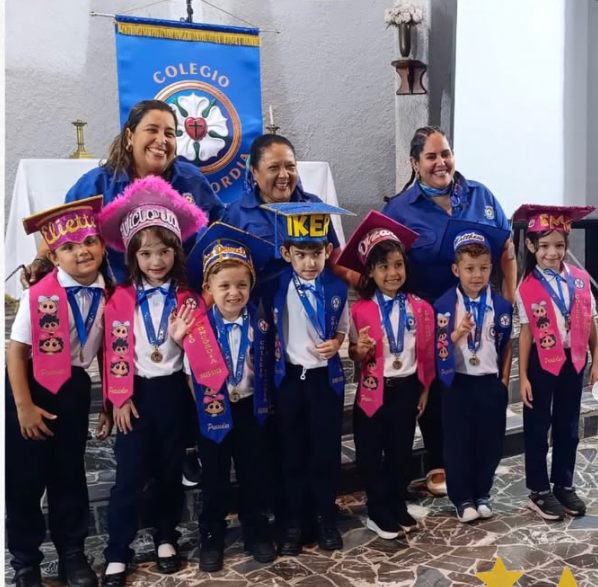 Pequeños estudiantes graduandos con su equipo educativo